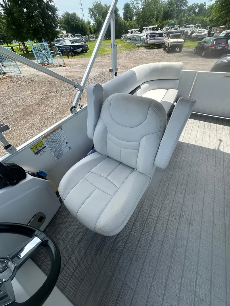 Slide: The Image of 2021 Godfrey SWEETWATER 2186 SB boat interior with white seating and steering wheel. - 14