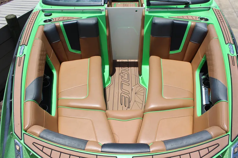 Slide: The Image of 2017 Nautique Super Air G23 boat interior with tan and green seating. - 14