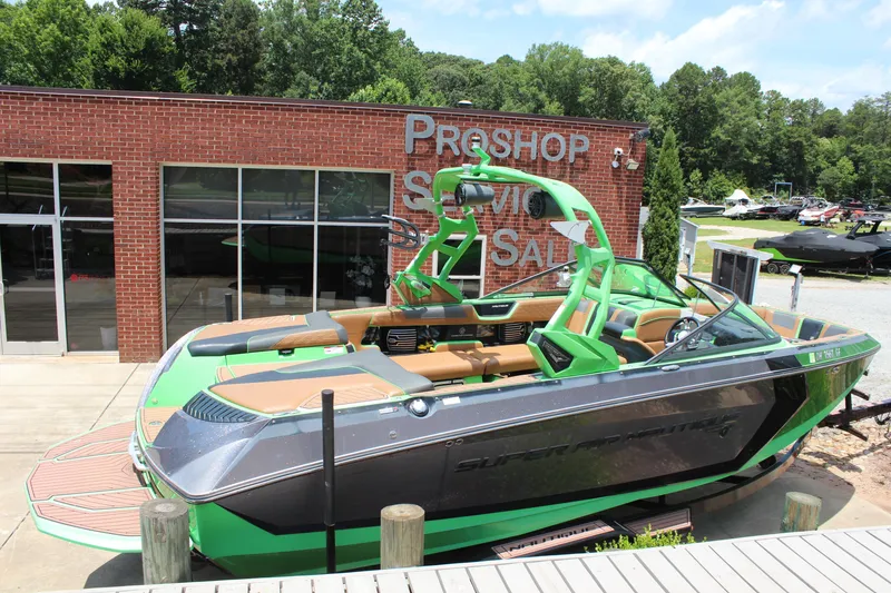 Slide: The Image of 2017 Nautique Super Air G23 boat in vibrant green, parked outside a pro shop. - 15