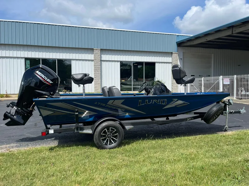 Slide: The Image of 2026 Lund 1775 Renegade SS boat on trailer, parked outside a building. - 1