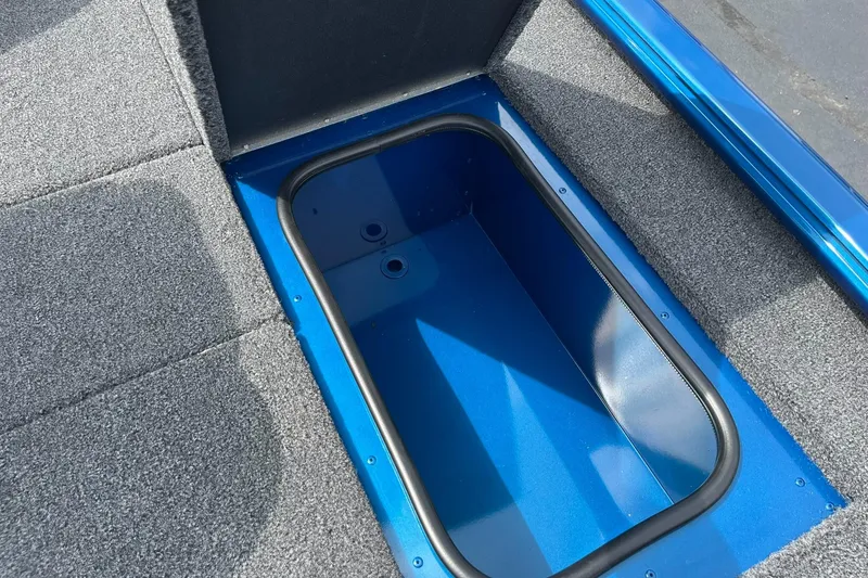 Slide: The Image of 2026 Lund 1775 Renegade SS boat storage compartment with blue interior and gray carpet. - 17