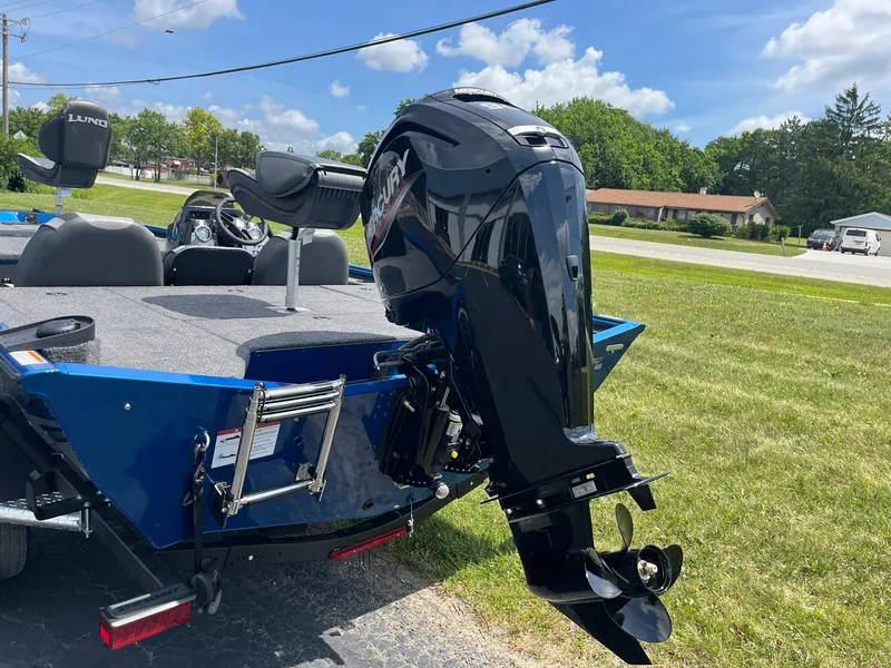 Slide: The Image of 2026 Lund 1775 Renegade SS boat with Mercury outboard motor on grassy area. - 2