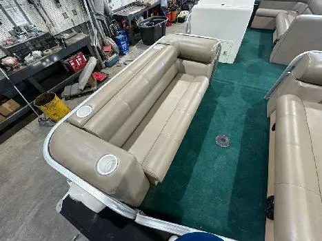 Slide: The Image of 2003 Odyssey Pontoons 2302 interior with beige seating and green carpet. - 3