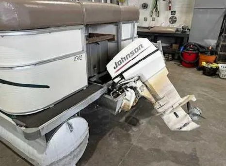 Slide: The Image of 2003 Odyssey Pontoons 2302 with Johnson outboard motor in a garage setting. - 6