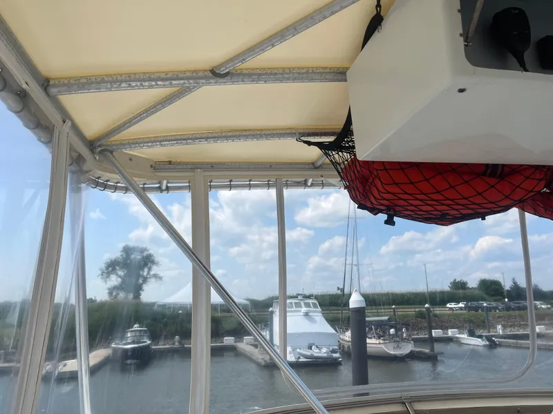 Slide: The Image of 1987 Tiara Yachts 3600 interior view with marina and boats in the background. - 10