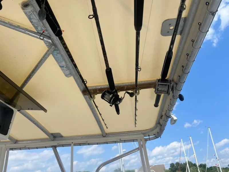 Slide: The Image of Fishing rods mounted on a 1987 Tiara Yachts 3600 boat under a clear blue sky. - 11