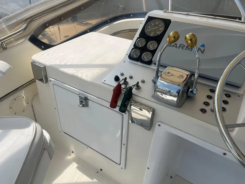 Slide: The Image of 1987 Tiara Yachts 3600 helm with controls, gauges, and steering wheel. - 16