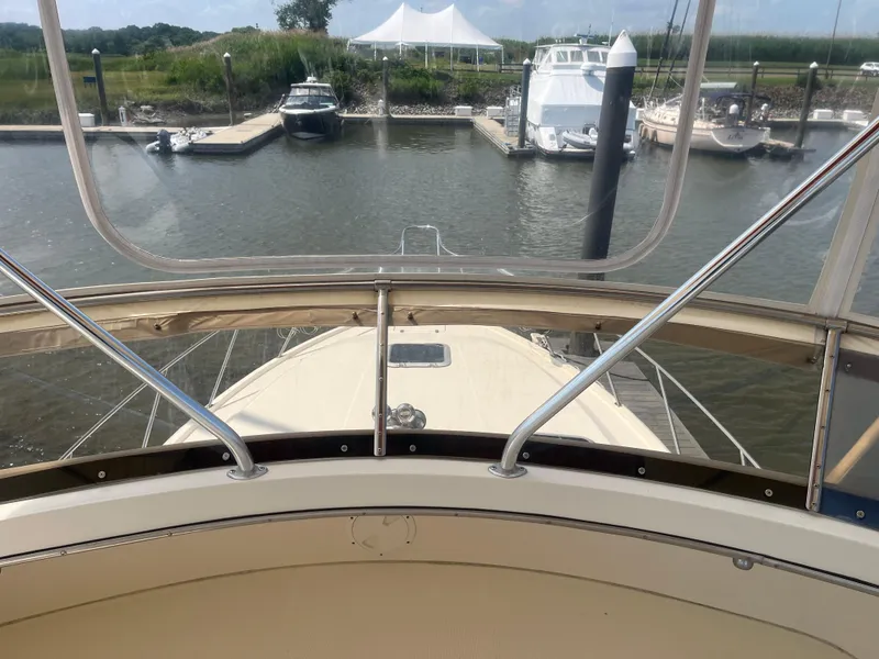 Slide: The Image of 1987 Tiara Yachts 3600 at marina, view from helm, surrounded by boats and greenery. - 18