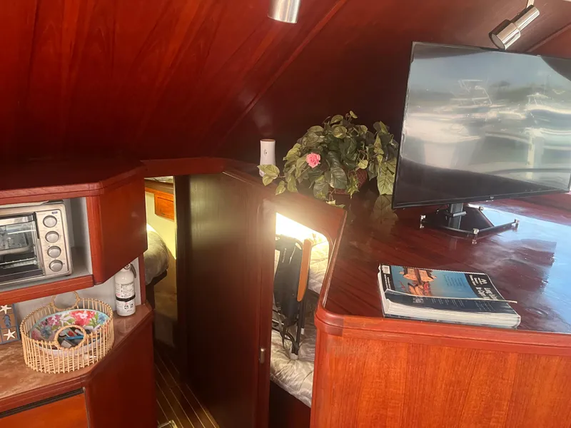 Slide: The Image of 1987 Tiara Yachts 3600 interior with TV, wooden cabinetry, and cozy cabin space. - 26