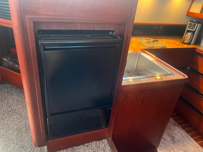 Slide: The Image of 1987 Tiara Yachts 3600 interior with wooden cabinetry, sink, and compact refrigerator. - 28