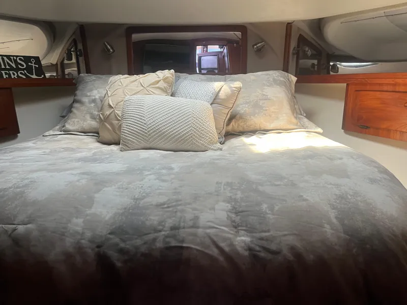 Slide: The Image of Cozy cabin interior of 1987 Tiara Yachts 3600 with plush bedding and wooden accents. - 34