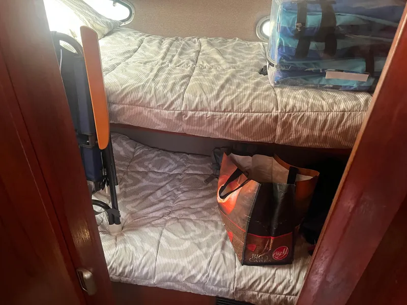 Slide: The Image of 1987 Tiara Yachts 3600 cabin with bunk beds and storage bags. - 37