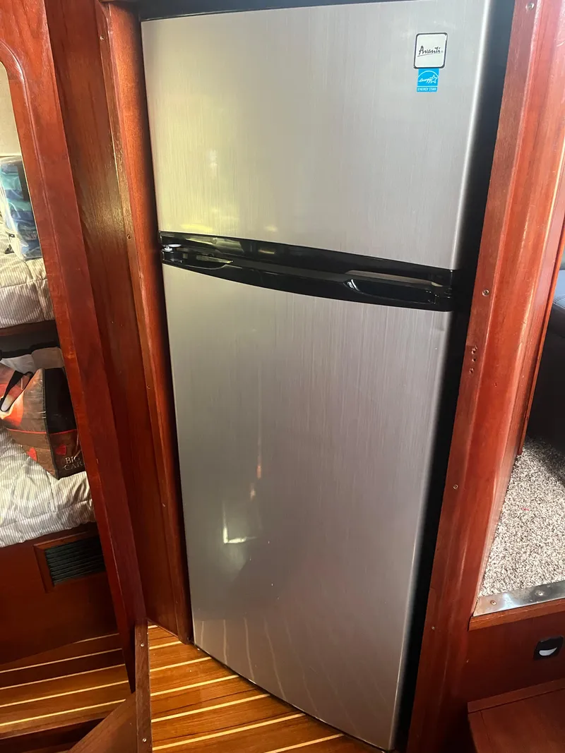 Slide: The Image of Stainless steel refrigerator inside 1987 Tiara Yachts 3600 cabin with wooden interior. - 38