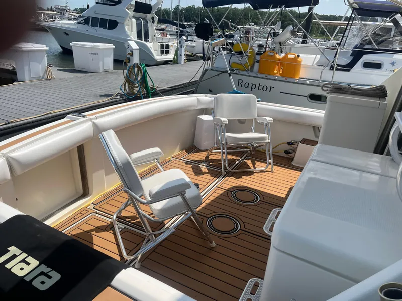 Slide: The Image of 1987 Tiara Yachts 3600 with seating area, docked at marina with other boats. - 9