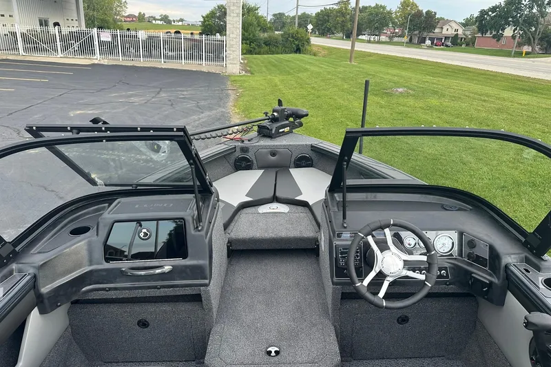 Slide: The Image of 2026 Lund 1775 Crossover XS boat interior with steering wheel and open windshield. - 12