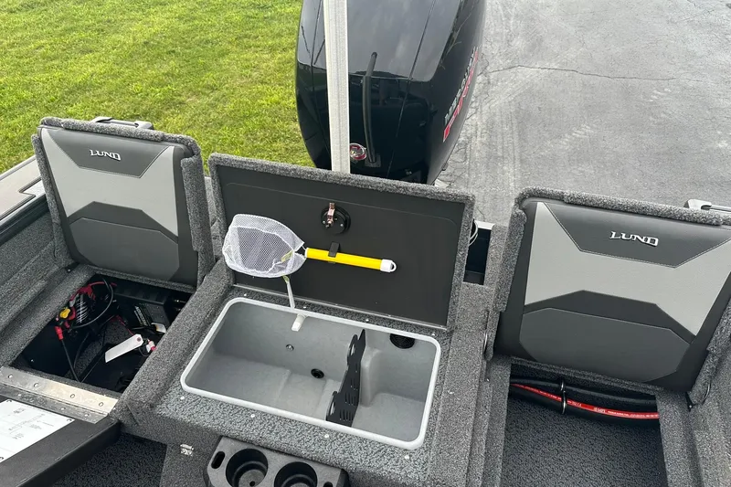 Slide: The Image of 2026 Lund 1775 Crossover XS boat interior with storage compartments and fishing net. - 16