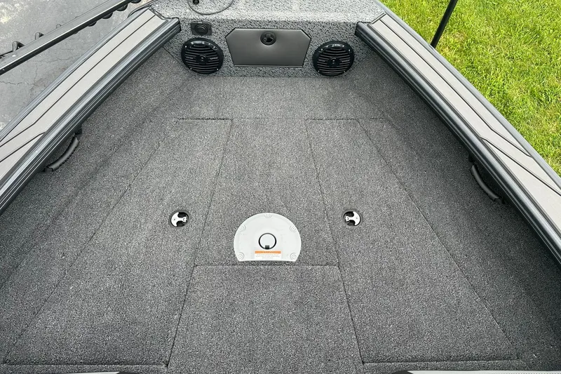 Slide: The Image of 2026 Lund 1775 Crossover XS boat interior with carpeted deck and storage compartments. - 18