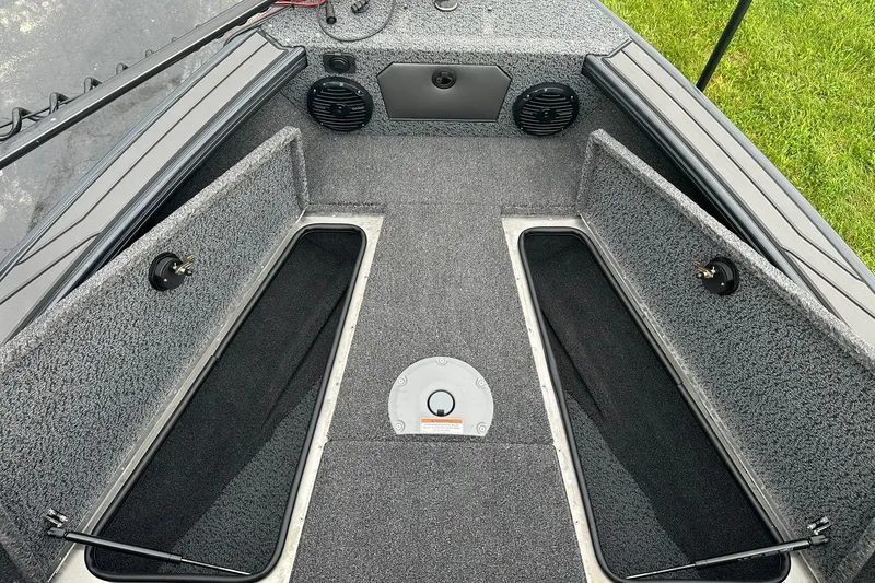 Slide: The Image of Interior view of 2026 Lund 1775 Crossover XS boat, featuring storage compartments and speakers. - 19
