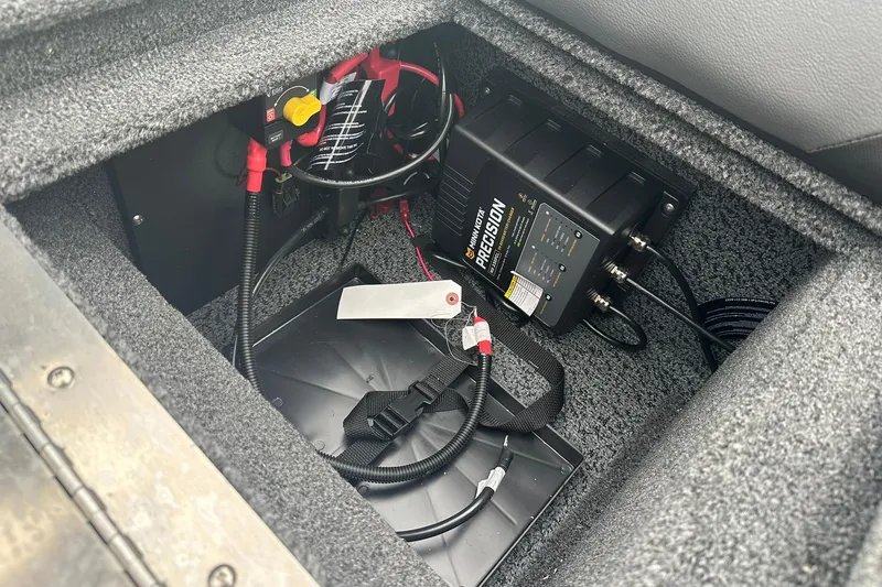 Slide: The Image of 2026 Lund 1775 Crossover XS boat battery compartment with Minn Kota Precision charger. - 33