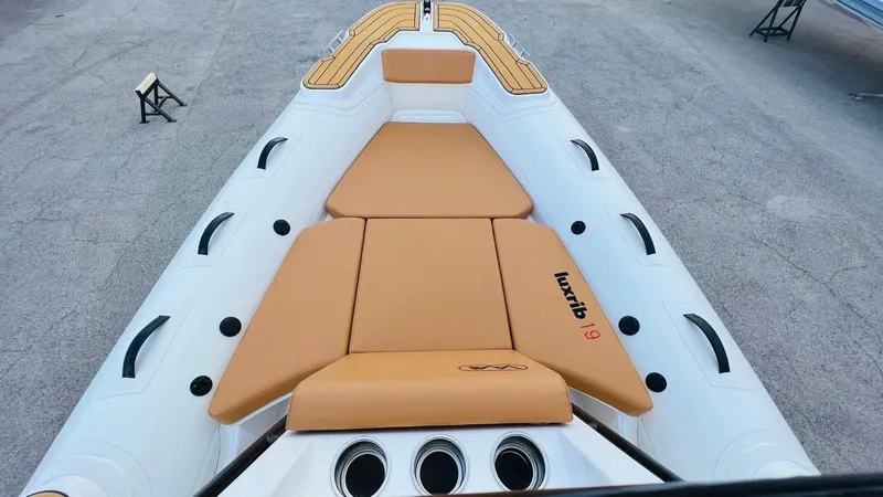 Slide: The Image of Aqvaboats Luxrib 19, 2025 model, featuring tan seating and sleek design. - 12