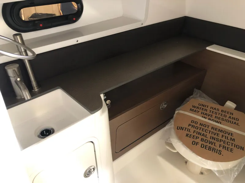 Slide: The Image of Interior of 2025 Sea Ray SDX 290 boat with sink and covered toilet. - 11