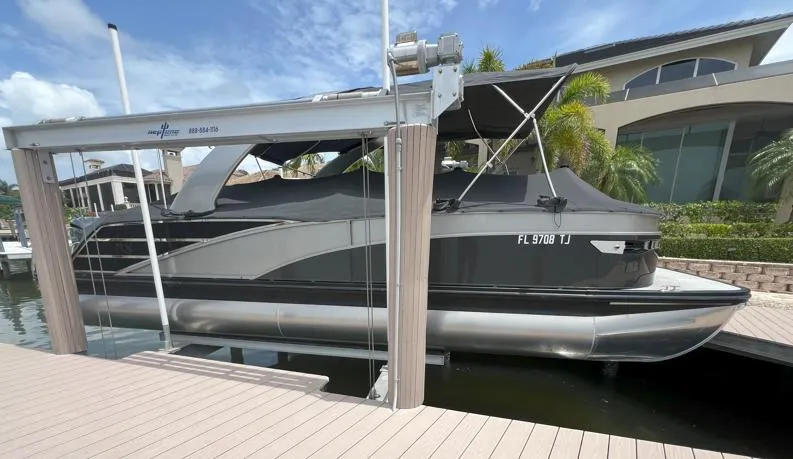 Slide: The Image of 2022 Bennington RX 25 RXFBA pontoon boat docked with cover on. - 1