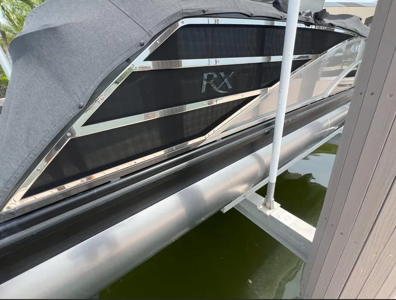 Slide: The Image of 2022 Bennington RX 25 RXFBA pontoon boat docked with cover. - 5