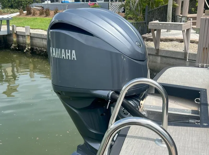Slide: The Image of Outboard Yamaha engine on a 2022 Bennington RX 25 RXFBA boat by the water. - 6