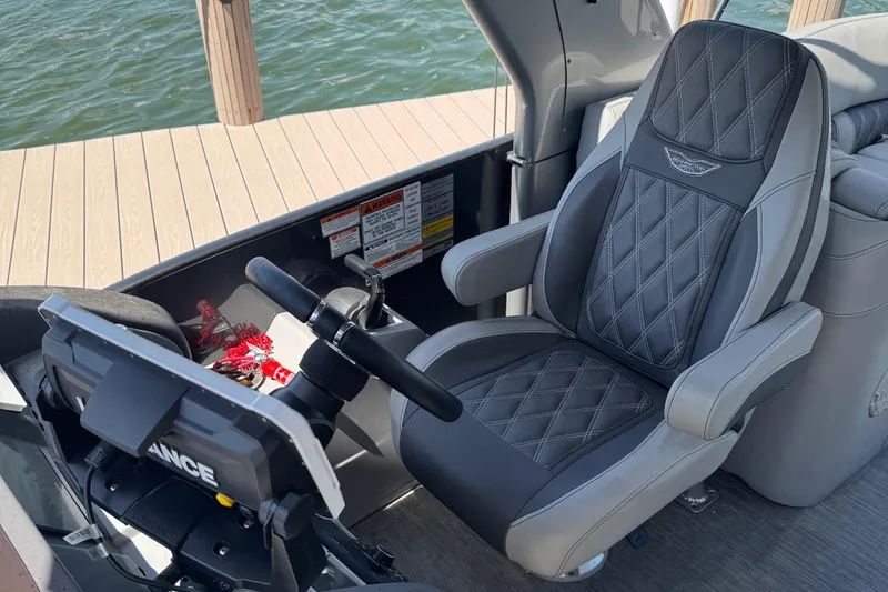 Slide: The Image of Captain's seat on 2022 Bennington RX 25 RXFBA boat, near water and dock. - 9