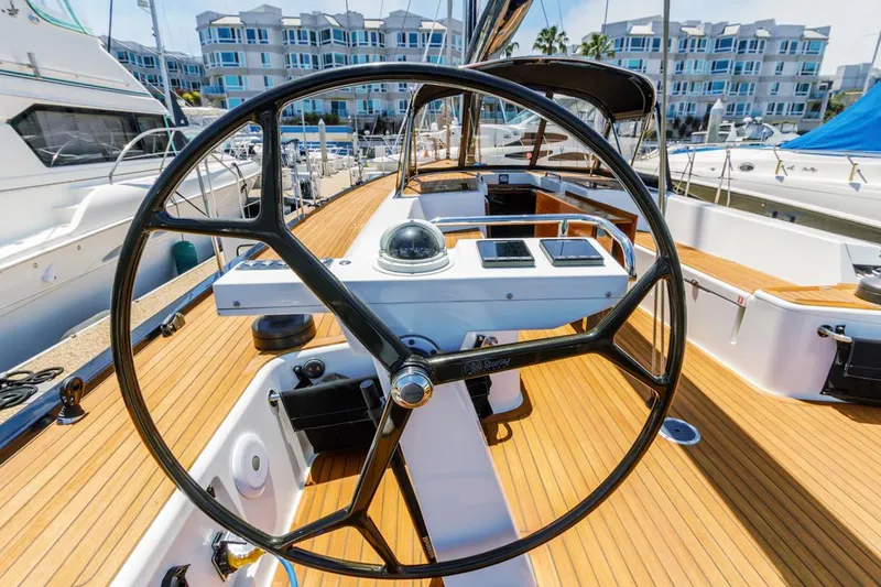 Slide: The Image of Steering wheel of a 2017 Solaris 50 yacht, docked at a marina with modern buildings. - 15
