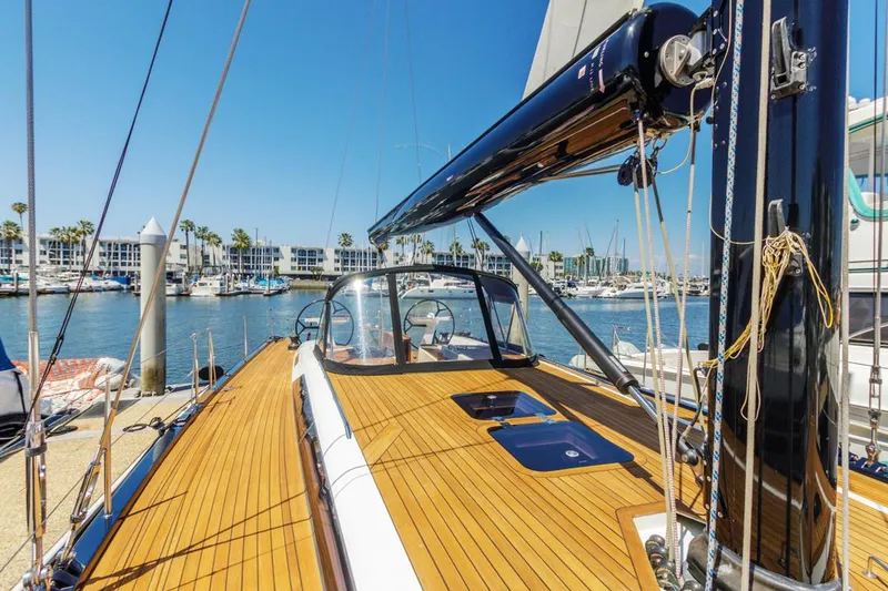 Slide: The Image of Luxurious 2017 Solaris 50 yacht docked in a sunny marina, showcasing sleek wooden deck. - 5