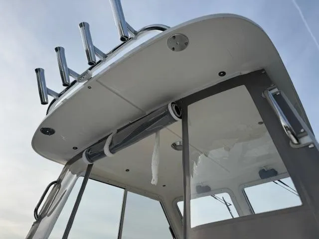 Slide: The Image of 2025 NorthCoast 235 HT boat cabin roof with rod holders and windows. - 10