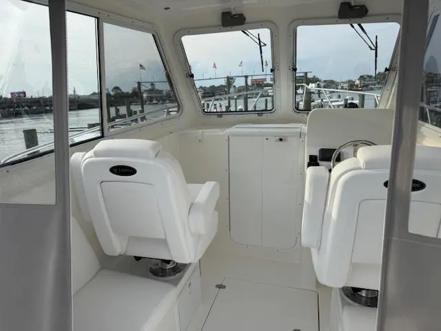 Slide: The Image of Interior of 2025 NorthCoast 235 HT boat with white seating and large windows. - 14