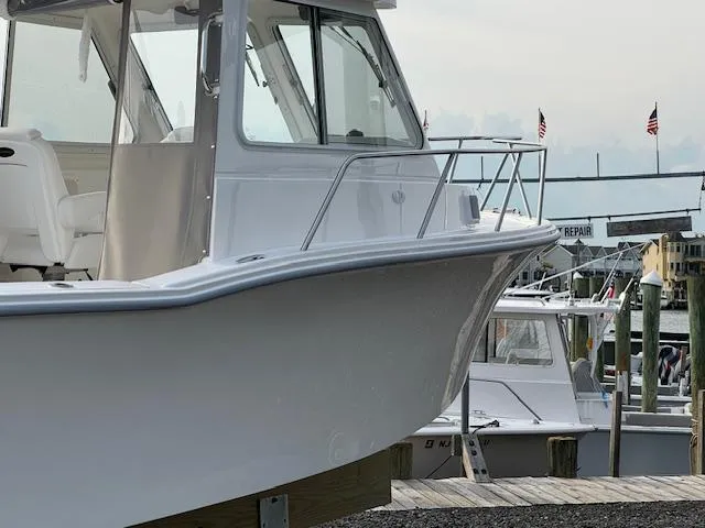 Slide: The Image of 2025 NorthCoast 235 HT boat docked at a marina with American flags in the background. - 4