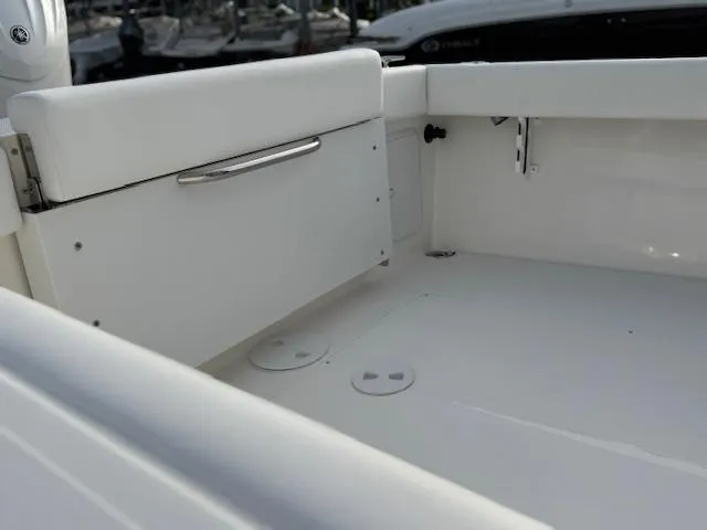Slide: The Image of 2025 NorthCoast 235 HT boat interior with white seating and storage compartment. - 8