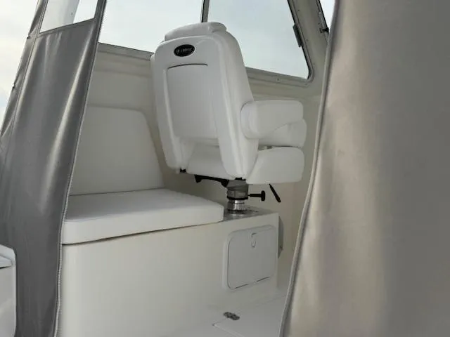 Slide: The Image of White interior seating of 2025 NorthCoast 235 HT boat with window view. - 9