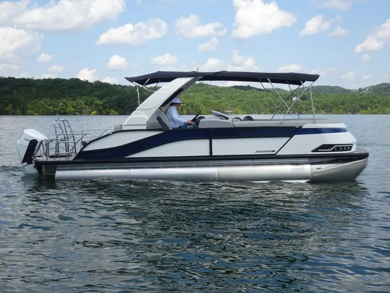 Slide: The Image of 2025 Harris Grand Mariner 250 pontoon boat on a lake under a blue sky. - 1