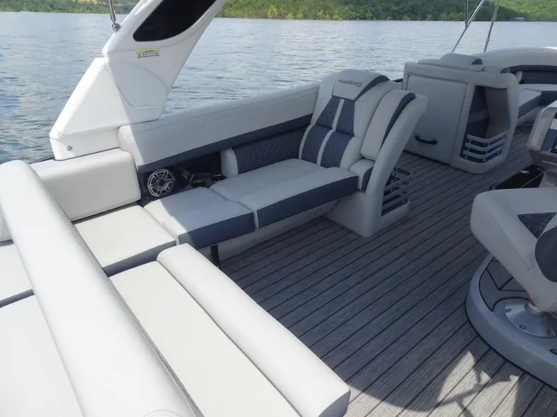 Slide: The Image of 2025 Harris Grand Mariner 250 boat interior with luxurious seating and sleek design on the water. - 13