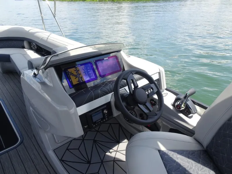 Slide: The Image of 2025 Harris Grand Mariner 250 boat dashboard with modern controls and dual screens on water. - 15