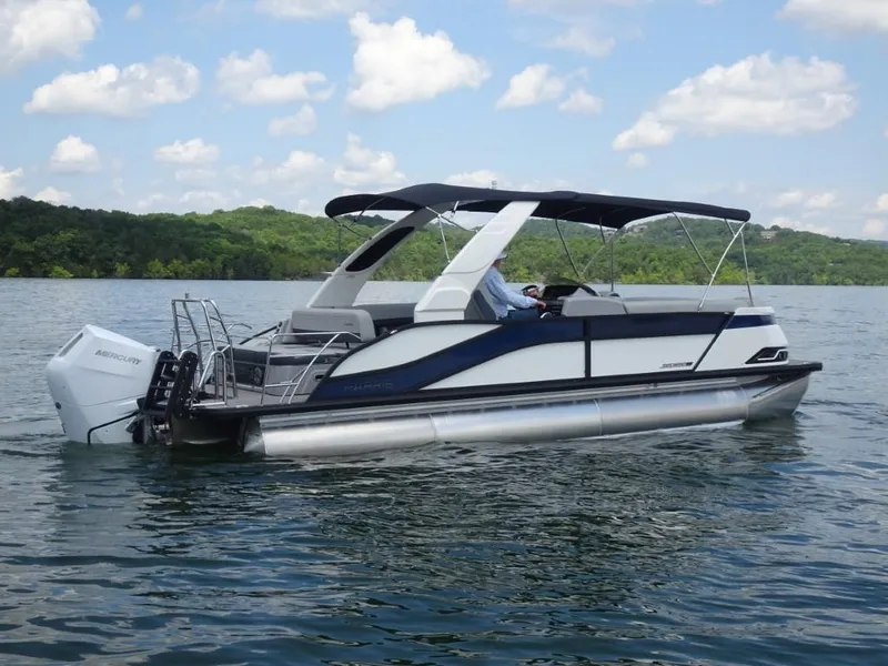 Slide: The Image of 2025 Harris Grand Mariner 250 pontoon boat on a lake under a blue sky. - 2