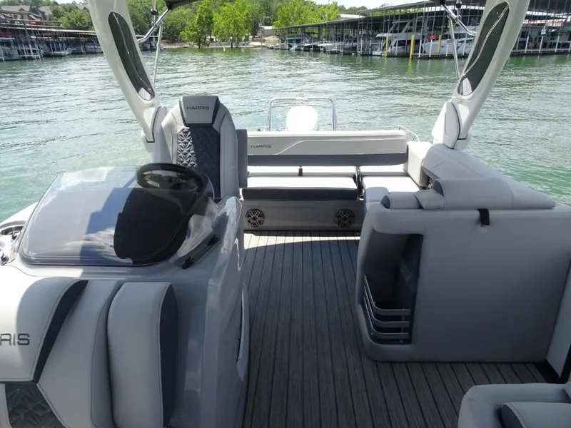 Slide: The Image of 2025 Harris Grand Mariner 250 boat interior with sleek seating and modern design on a sunny day. - 23