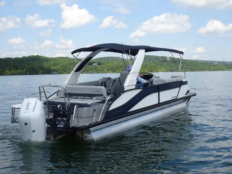Slide: The Image of 2025 Harris Grand Mariner 250 pontoon boat cruising on a lake under a blue sky. - 3