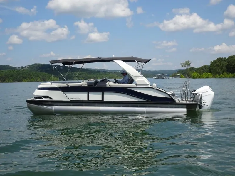Slide: The Image of 2025 Harris Grand Mariner 250 pontoon boat on a lake under a blue sky. - 6