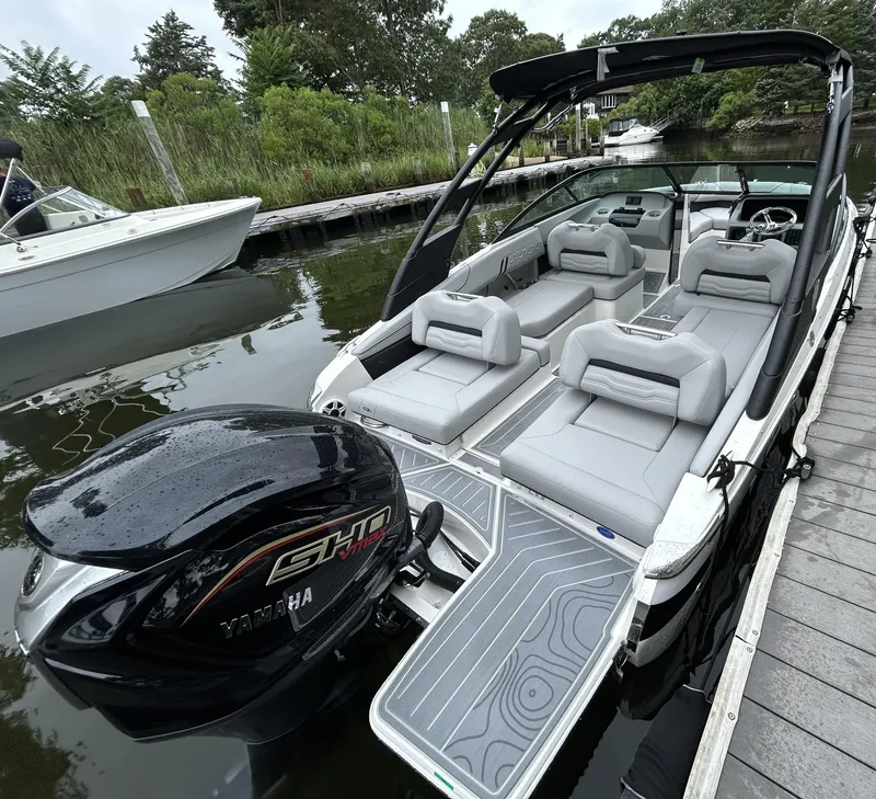 Slide: The Image of 2026 Regal LX2 boat with Yamaha engine docked, featuring sleek gray seating and modern design. - 1