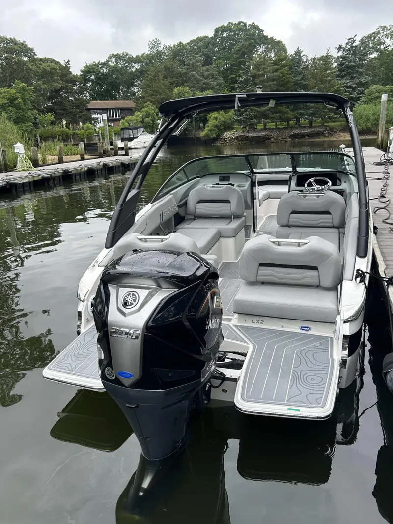 Slide: The Image of 2026 Regal LX2 boat with Yamaha engine docked on a calm lake. - 2