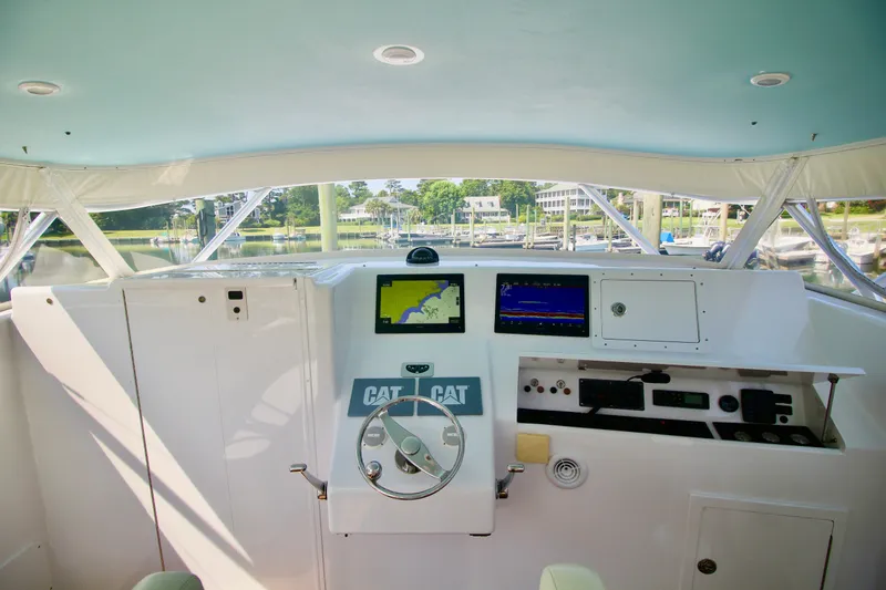 Slide: The Image of 2007 Custom Carolina Layton Express boat helm with navigation screens and steering wheel. - 10