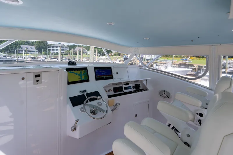 Slide: The Image of Interior of 2007 Custom Carolina Layton Express boat with modern navigation equipment and white seating. - 11