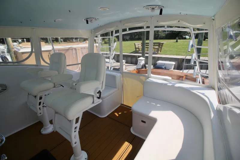 Slide: The Image of Interior of 2007 Custom Carolina Layton Express boat with white seating and wooden flooring. - 17