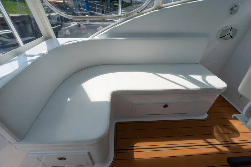 Slide: The Image of 2007 Custom Carolina Layton Express boat interior with white seating and wooden flooring. - 18