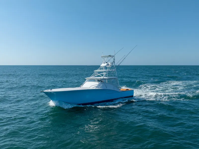 Slide: The Image of 2007 Custom Carolina Layton Express boat cruising on open sea under clear blue sky. - 2